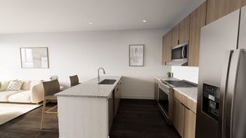 A modern kitchen with a white island and stainless steel appliances. at The Logan Luxury Apartments, Nampa